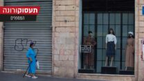 אישה עם מסכה צועדת לצד חנויות סוגרות ברחוב יפו בירושלים. 1 באוקטובר (צילום: נתי שוחט/פלאש90)