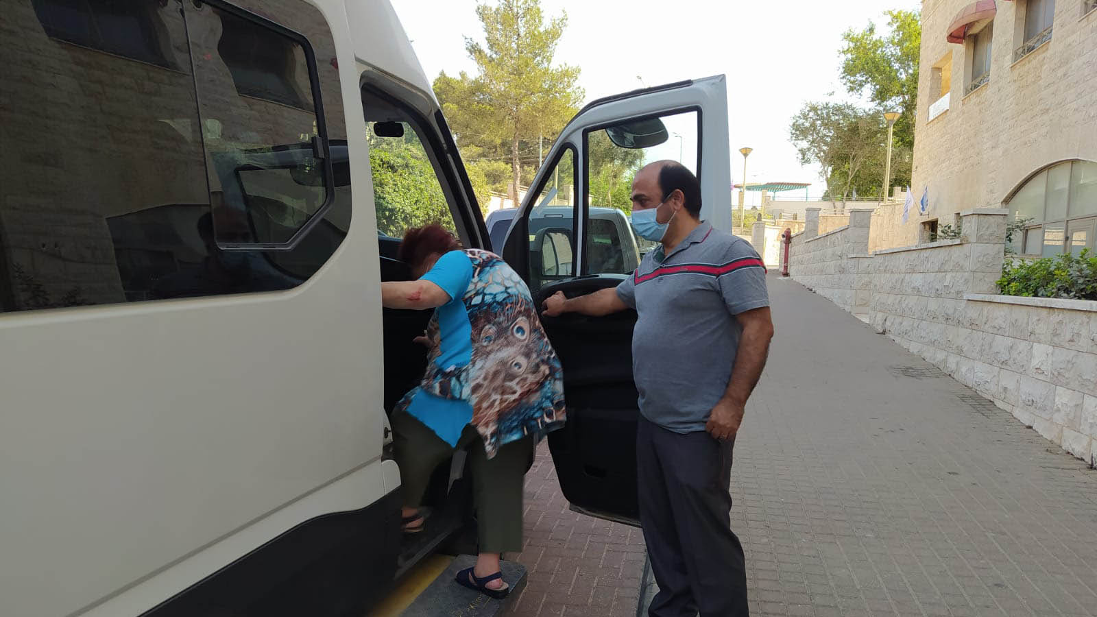 אמיר חנוך, אחראי על ההסעות במנהל החינוך, מסייע לתושבת לחזור לביתה בבטחה (צילום: יהל פרג')