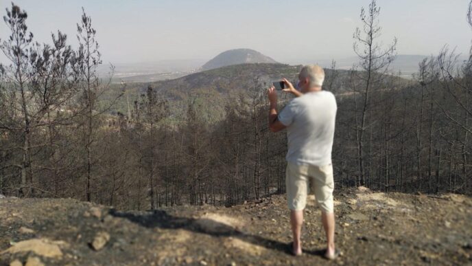 Residents document the burned forest at the northern entrance to Nof HaGalil. (Photo: Yahel Faraj)