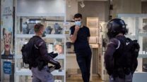 שוטרים בפתח חנות אוכפים את הנחיות הסגר (צילום: נתי שוחט/פלאש90)