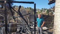 סרגיי בוצניקוב בחצר שנשרפה. "אני בעצמי עשיתי הכל, דק ופרגולה, גינה מסביב. האש שרפה הכל" (צילום: שי ניר)