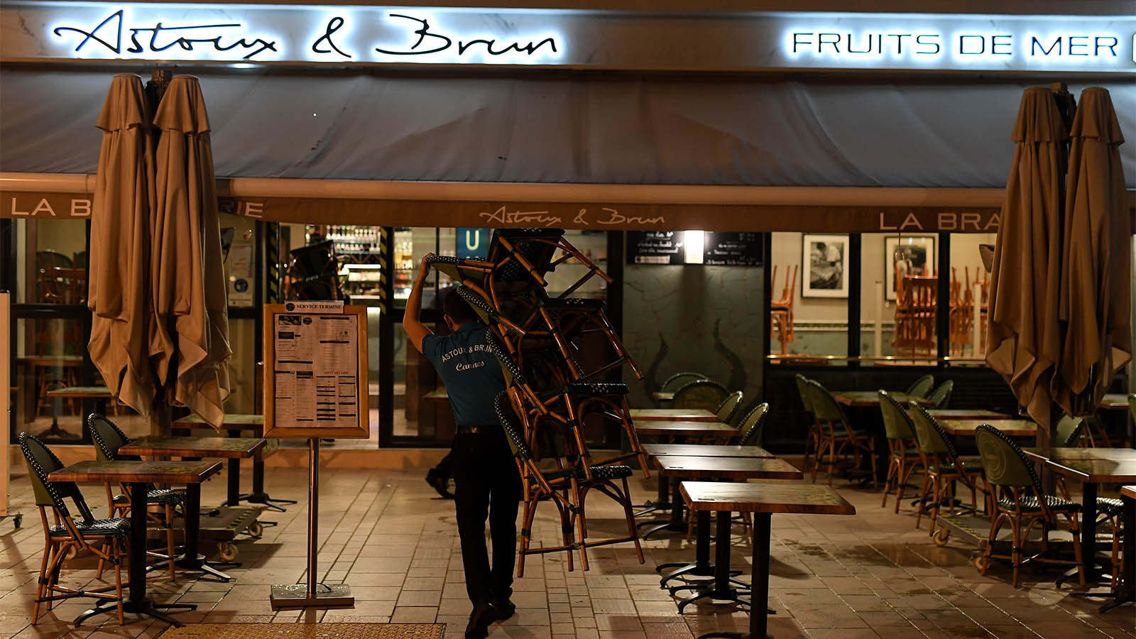 עובד מסעדה סוגר לקראת העוצר הלילי בעיר קאן בצרפת (צילום: Pascal Le Segretain/Getty Images)