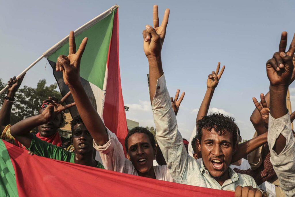 مواطنون سودانيون يحتفلون في شوارع العاصمة الخرطوم بالاتفاق الذي تم إنجازه بين قادة المعارضة والاتحادات المهنية وبين الحكومة الانتقالية المؤقتة، 5 تموز/ يوليو 2019. (تصوير: AP)