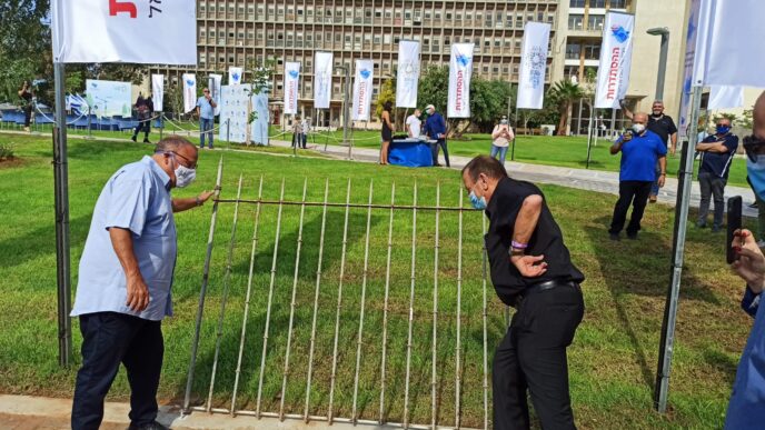Arnon Bar-David and Tel Aviv mayor Ron Huldai taking down the fences surrounding the Histadrut garden in Tel Aviv, October 2020. (Photo: Nizzan Zvi Cohen)