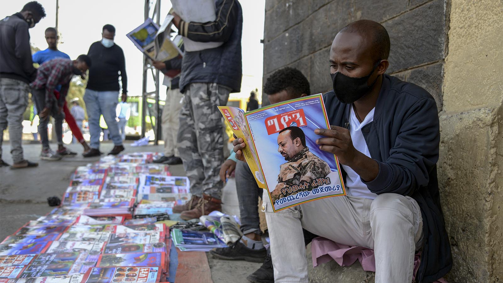 קוראים עיתונאים ומגזינים שמדחווים על הלחימה במדינה. (צילום: AP/Samuel Habtab)