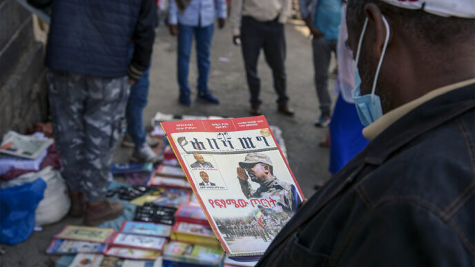 אתיופים קוראים דיווחים על מלחמת האזרחים בתיגראי. אדיס אבבה, נובמבר 2020 (צילום: AP Photo/Samuel Habtab)