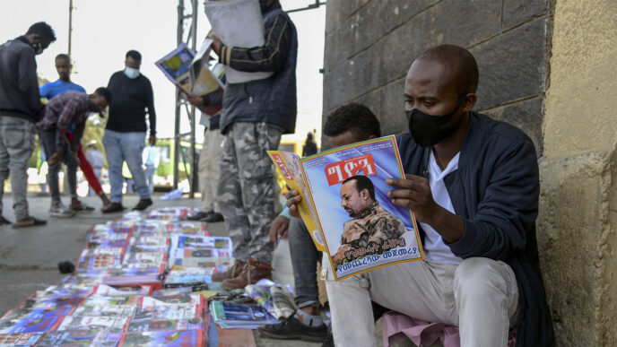 אתיופים קוראים דיווחים על מלחמת האזרחים בתיגראי. אדיס אבבה, נובמבר 2020 (צילום: AP Photo/Samuel Habtab)