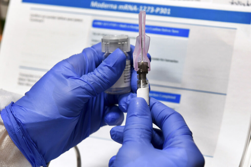 אחות מכינה זריקה במסגרת בניסוי החיסון לקורונה של חברת מודרנה. הדור הבא של החיסונים נמצא בפיתוח, עם התמקדות בווריאנטים המדאיגים (צילום: AP/Hans Pennink)