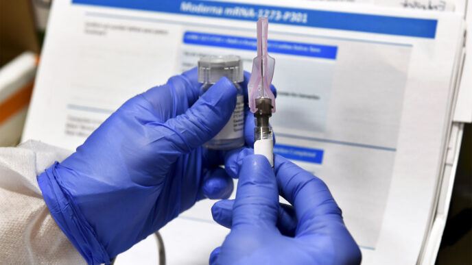 אחות מכינה זריקה בניסוי החיסון לקורונה של חברת מודרנה (צילום: AP/Hans Pennink)