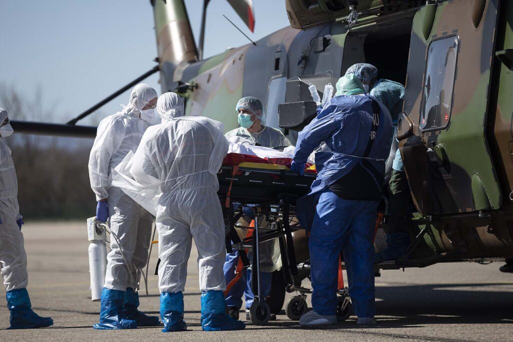 צוות רפואי מכין מטופל עם קורונה להובלה בשוויץ. (צילום: AP/Jean-Francois Badias)