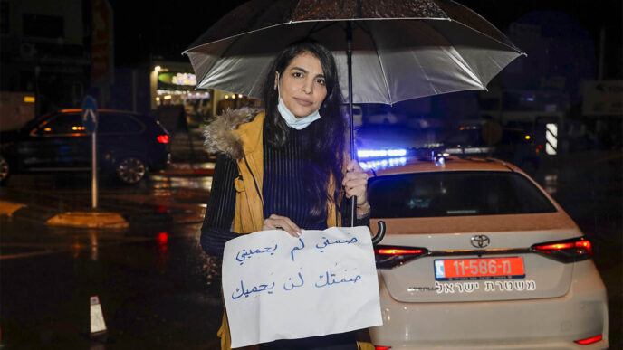 المحامية ميناس العي في مظاهرة في عرابة في أعقاب مقتل وفاء عباهرة على يد زوجها السابق. "صمتك لن يحميك" (تصوير: غيلعاد شريم)
