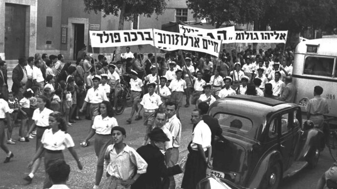 Youth movement members carry banners with names of ships that illegally transported Jewish immigrants to Israel during the British Mandate period. May Day 1947, Tel Aviv (Photo: Hans Finn)