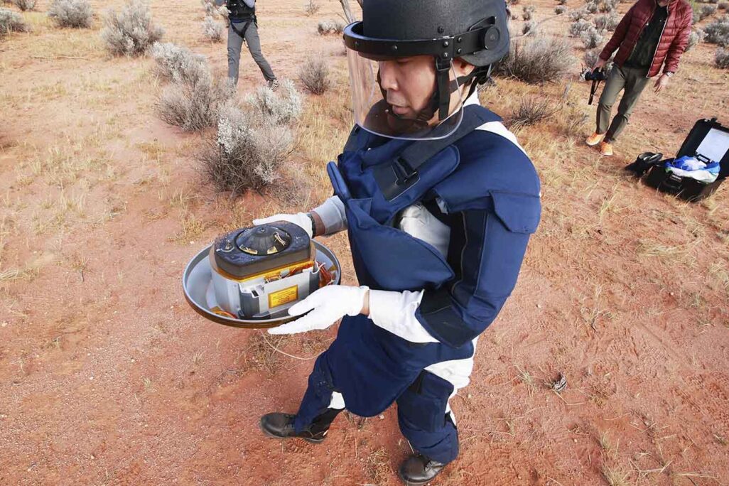 עובד סוכנות החלל היפנית עם הקפסולה שבתוכה דגימות האסטרואיד באוסטרליה. 6 בדצמבר 2020 (JAXA via AP)