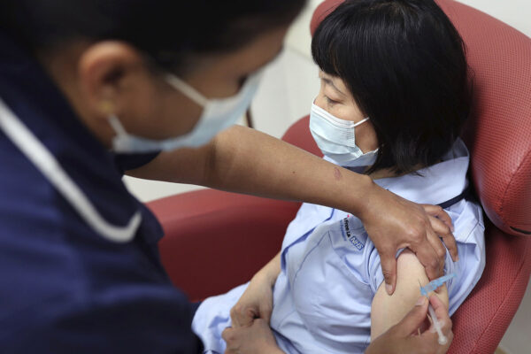 אחות מדגימה מתן חיסון לקורונה, כחלק מהכנת הצוותים הרפואיים למתבע החיסון בבריטניה. (צילום: Yui Mok/Pool Photo via AP)