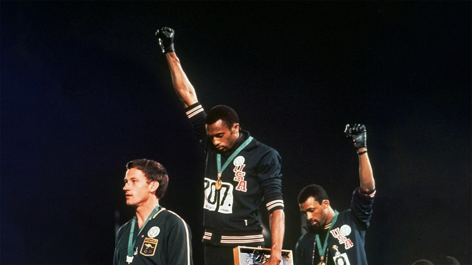 הצדעת הכוח השחור באולימפיאדת מקסיקו 1968 &#8211; ג'ון קרלוס (מימין) טומי סמית' ופיטר נורמן בטקס הענק המדליות בריצת 200 מטר (צילום: AP)