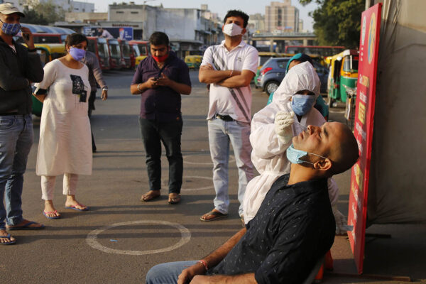 עובד רפואי עושה בדיקת קורונה באחמדאבאד, הודו. (צילום: AP/Ajit Solanki)