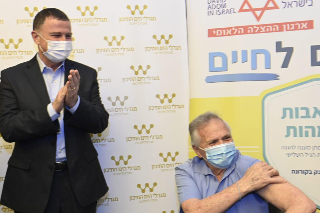 השר יולי אדלשטיין עם המתחסן הראשון במסגרת פרוייקט "מגן אבות ואמהות" (צילום: חורחה נובומינסקי, לע"מ) השר יולי אדלשטיין עם המתחסן הראשון במסגרת פרוייקט "מגן אבות ואמהות" (צילום: חורחה נובומינסקי, לע"מ)