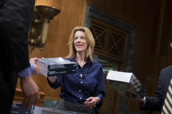 סטפני קלטון, מבכירות כלכלניות ה-MMT, מקבלת לידיה עותק של תקציב ממשל אובמה לשנת 2016 בתוקף תפקידה ככלכלנית בוועדת התקציב של הסנאט האמריקאי, פברואר 2015.  (Photo By Tom Williams/CQ Roll Call)