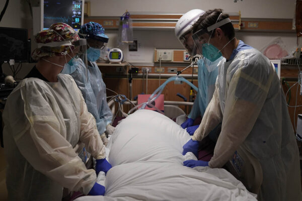 צוות רפואי מטפל בחולה קורונה בבי"ח בפרבר של לוס אנג'לס, קליפורניה. 22 בדצמבר (צילום: AP Photo/Jae C. Hong, File)