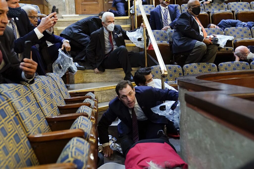 אנשים תופסים מחסה באחד מאולמות בית הנבחרים (צילום: AP Photo/Andrew Harnik)