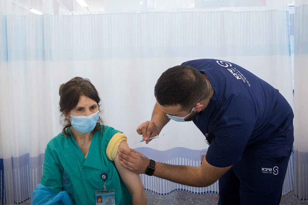 עובדת בית החולים שיבא מקבלת את מנת החיסון השניה (צילום: מרים אלסטר/פלאש 90)