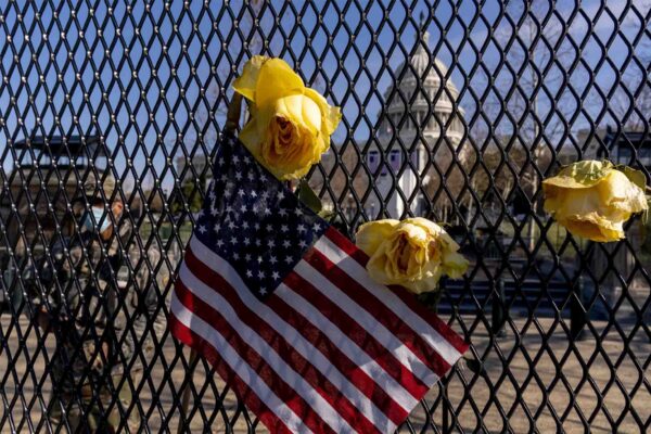 פרחים ודגל ארה"ב על גדר מול בניין הקפיטול, לזכר השוטר בריאן סיקניק שנהרג במהומות תומכי טראמפ. "האופן בו תגיב אמריקה, ילמד על הכיוון אליו צועדת המדינה" (צילום: AP Photo/Andrew Harnik)