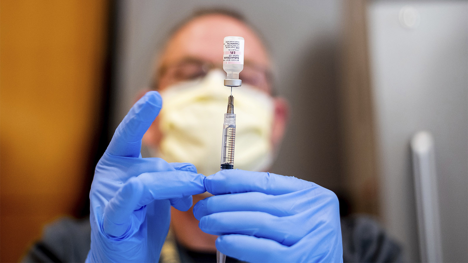 רוקח מכין מנת חיסון נגד קורונה של חברת פייזר. (צילום: AP Photo/Noah Berger, Pool)