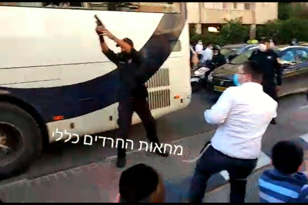 שוטר יורה כדור באוויר ברחוב זבוטיסקי בבני ברק. (צילום: מחאות החרדים)