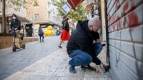 אדם סוגר חנות בירושלים במהלך הסגר (צילום: יונתן זינדל/פלאש90)