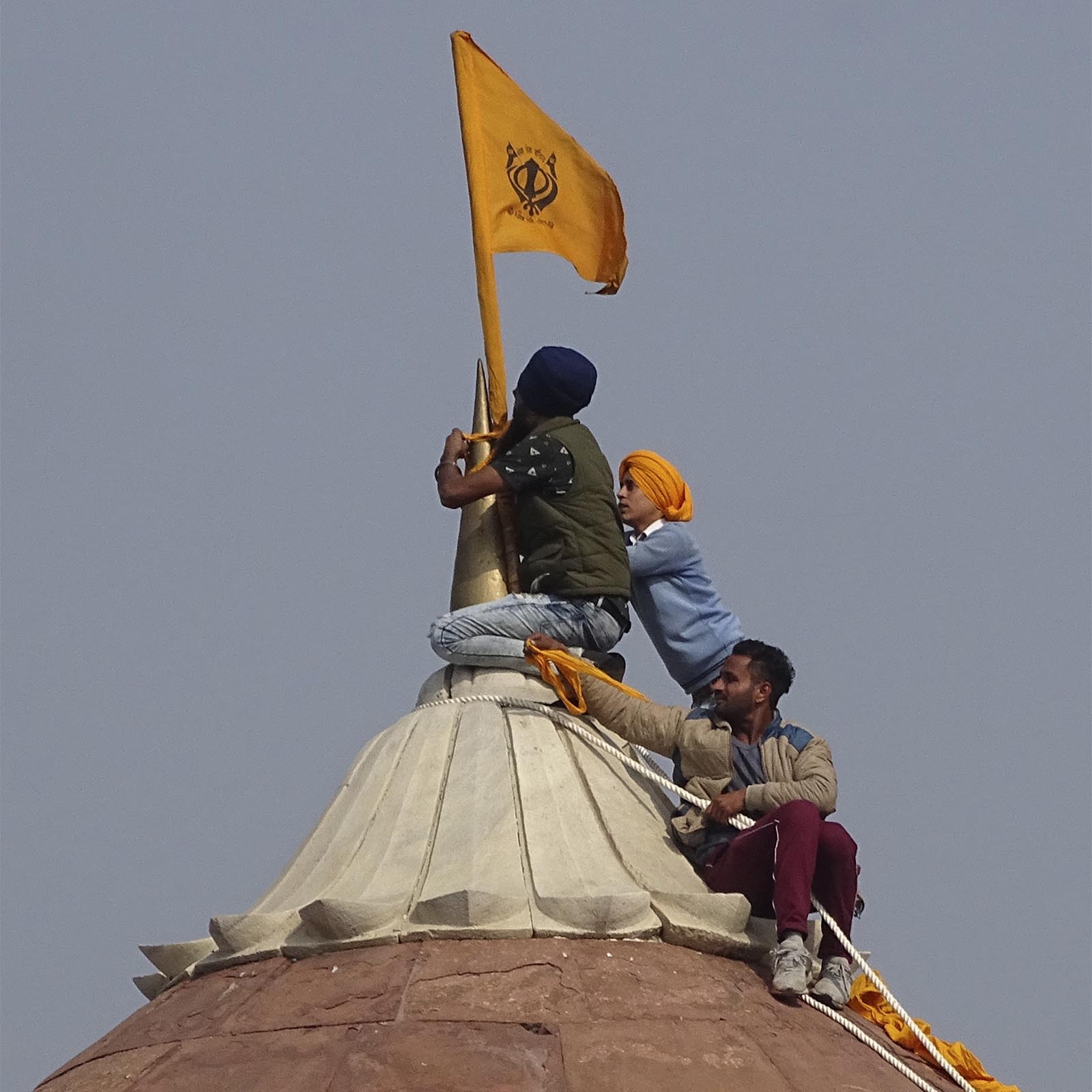 המוחים מניפים את דגל הסיקים בראש המצודה האדומה (צילום: AP Photo/Dinesh Joshi)