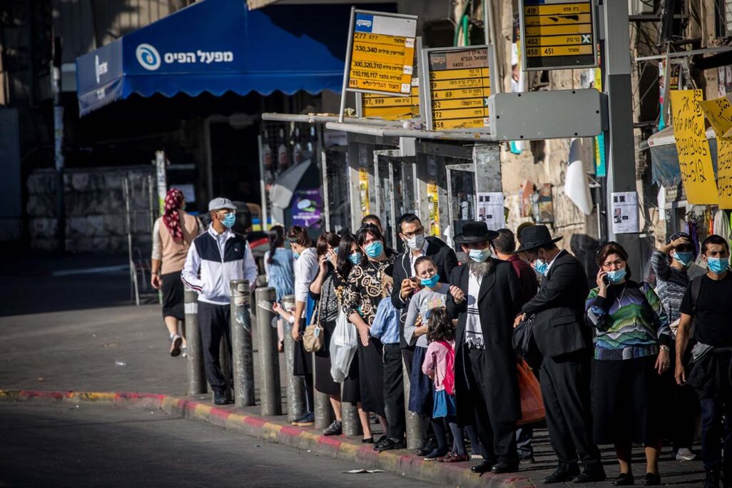 Ultra-orthodox jews waiting for a bus at the Bar-Ilan junction in Jerusalem, October 19, 2020. (Photo: Yonatan Sindel/Flash90)