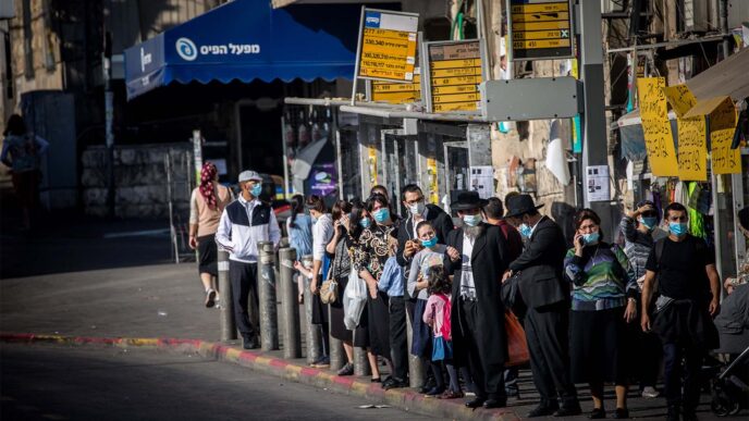 Ultra-orthodox jews waiting for a bus at the Bar-Ilan junction in Jerusalem, October 19, 2020. (Photo: Yonatan Sindel/Flash90)
