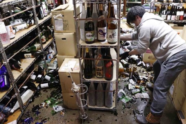 עובד בחנות משקאות בפוקשימה, לאחר רעידת האדמה (צילום: Kyodo via Reuters Connect)