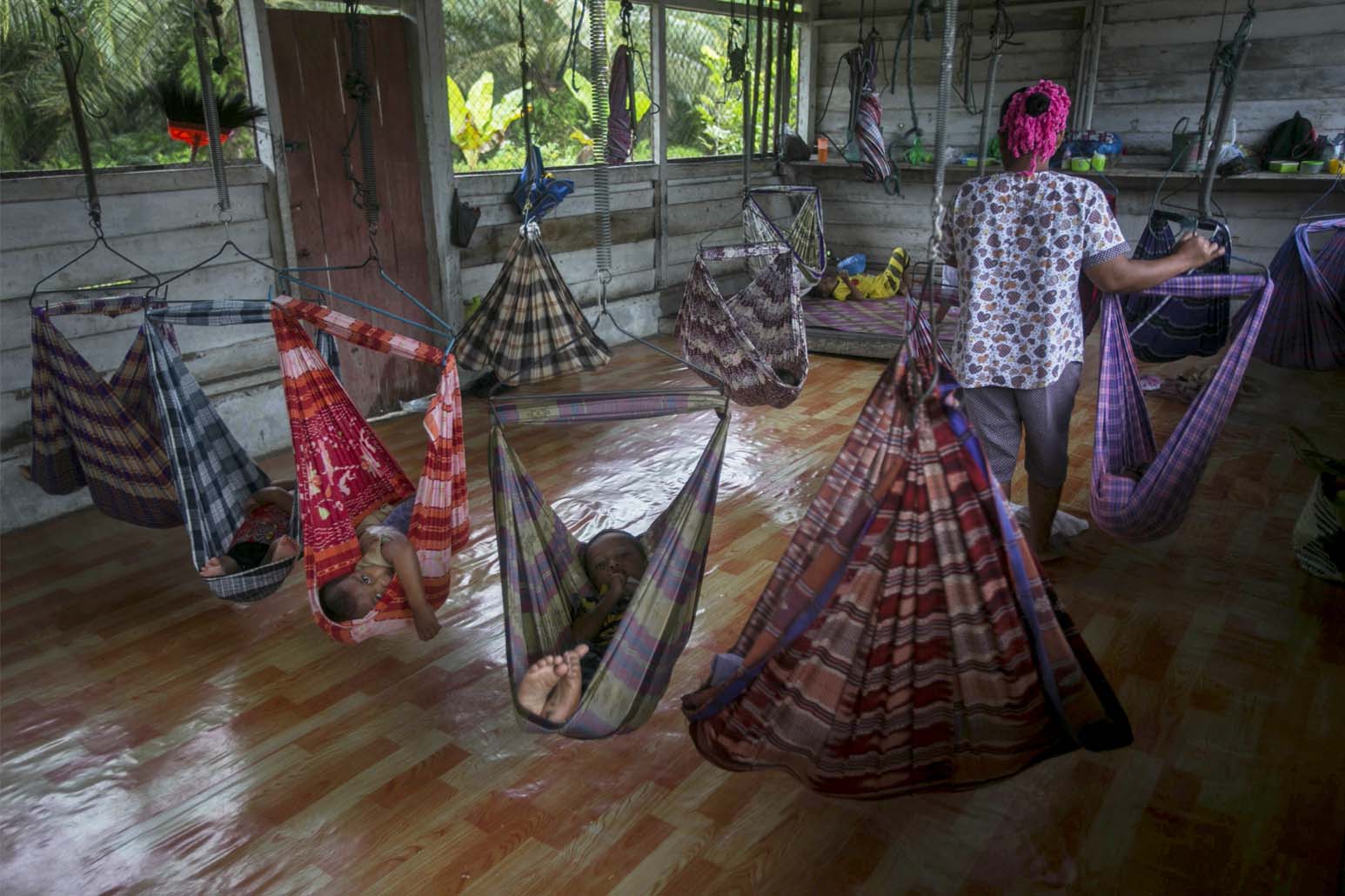 מעון יום מאולתר במטעי סומטרה אינדונזיה. נשים רבות לא יכולות להרשות לעצמן מעון מסודר והן נאלצות לקחת את הילדים איתן למטעים. (AP Photo/Binsar Bakkara)
