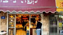 אלון אלגרבלי, הבעלים של "קפה ניצה" בחיפה משרת את הלקוחות הראשונים של היום ומעדיף כרגע להשאיר את הכיסאות והשולחנות במחסן (צילום: שי ניר)