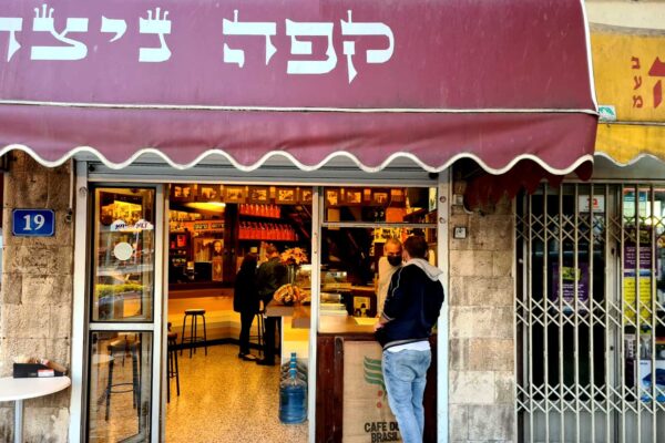 אלון אלגרבלי, הבעלים של "קפה ניצה" בחיפה משרת את הלקוחות הראשונים של היום ומעדיף כרגע להשאיר את הכיסאות והשולחנות במחסן (צילום: שי ניר)