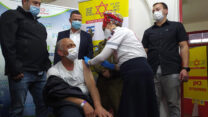 שר הבריאות יולי אדלשטיין ורשיד מראר שמתחסן במצע החיסונים לעובדים פלסטינים באזור התעשייה ברקן (צילום: יהל פרג')