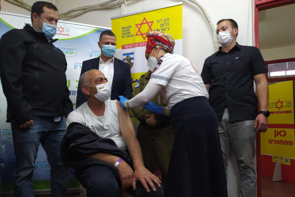 שר הבריאות יולי אדלשטיין ורשיד מראר שמתחסן במצע החיסונים לעובדים פלסטינים באזור התעשייה ברקן (צילום: יהל פרג')