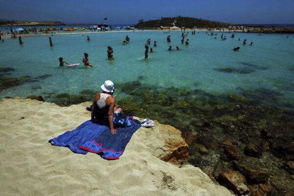 תיירים שוחים בחוף בקפריסין. (צילום ארכיון: AP/Petros Karadjias)