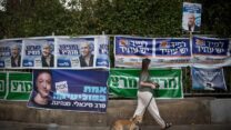 שלטי מפלגות בחצר של קלפי. (צילום: מרים אלסטר/פלאש90)