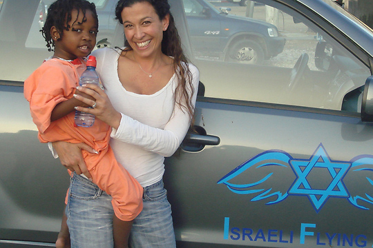 غال لوسكي مع طفلة من إحدى الدول التي تعمل فيها منظمة "المساعدات الإسرائيلية المنقولة جوا". "الخوف الوحيد الذي لدي والذي هو أقوى من الخوف من الموت، هو الخوف من أن أعيش حياتي بدون مغزى/ هدف" (تصوير: المساعدات الإسرائيلية المنقولة جوا)