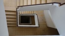 חדר המדרגות בבניין ברחוב מסדה, חיפה. אדריכלים: בנימין אוראל ויחזקאל זוהר. חדרי המדרגות של ימינו סגורים בחדרים אטומים, מאחורי דלתות כבדות ומוארים בתאורה חיוורת. לא תמיד זה היה כך (צילום: מיכאל יעקובסון)