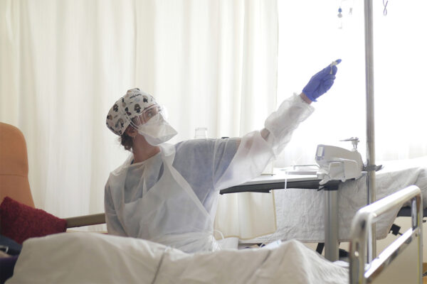 אחות מטפלת בחולה קורונה ביחידה לטיפול נמרץ במרפאת אמברויז פאר בנוילי-סור-סיין, ליד פריז. (צילום: AP/Thibault Camus, File)