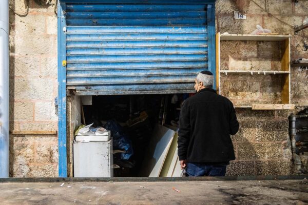 אדם סוגר חנות בשוק מחנה יהודה (צילום אילוסטרציה: יונתן זינדל/פלאש90)