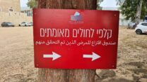 שלט הכוונה לקלפי חולים מאומתים בראש פינה (צילום: דפנה איזברוך)