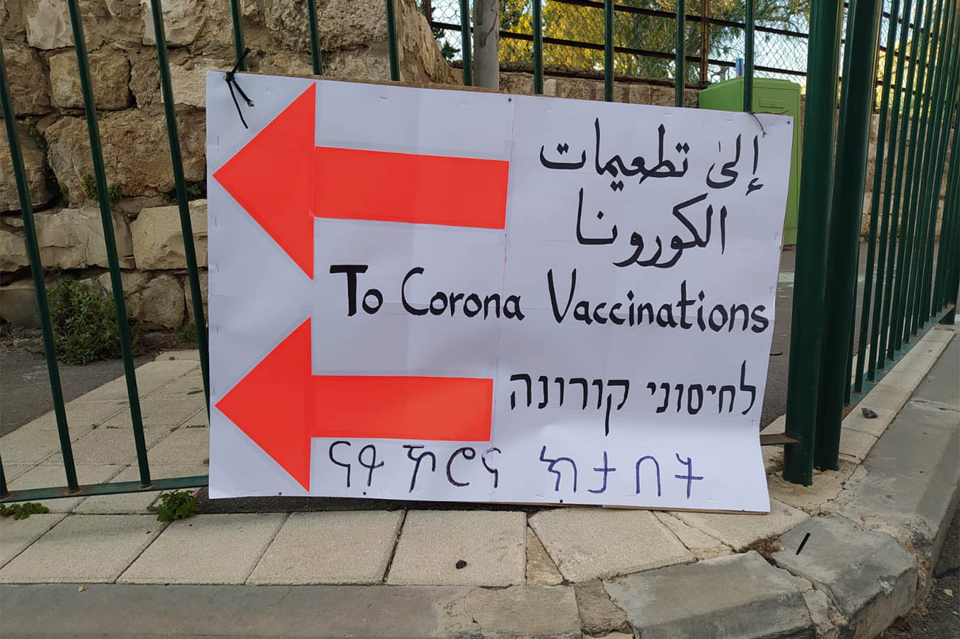 لافتة توجيه إلى مركز التطعيمات لمن ليس لديهم مكانة قانونية في حيفا. (تصوير: ياهل فرج)