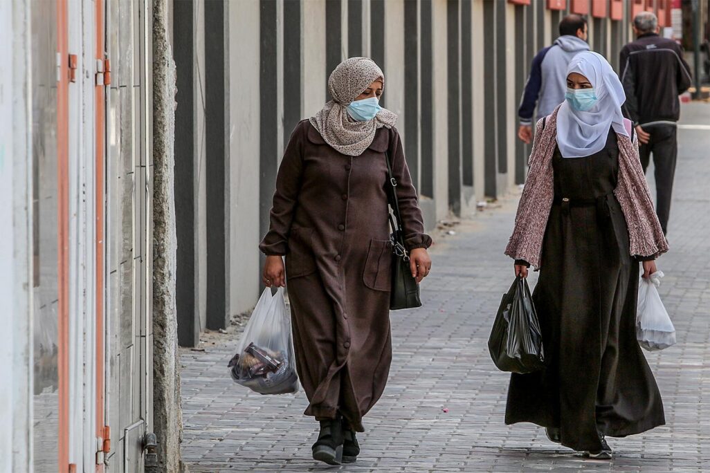 נשים הולכות עם מסכות ברצועת עזה (צילום: עבד אל רחים כתיב/פלאש90)