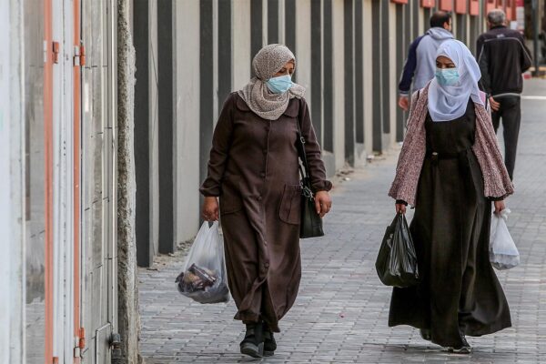 נשים הולכות עם מסכות ברצועת עזה (צילום: עבד אל רחים כתיב/פלאש90)