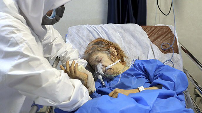 חולת קורונה בבית החולים שהדא-א-טג׳ריש. התמונות של החולים הנאבקים לשאוף אוויר לא מספיקות כדי לגרום לאנשים להישאר בבית (AP Photo/Ebrahim Noroozi)