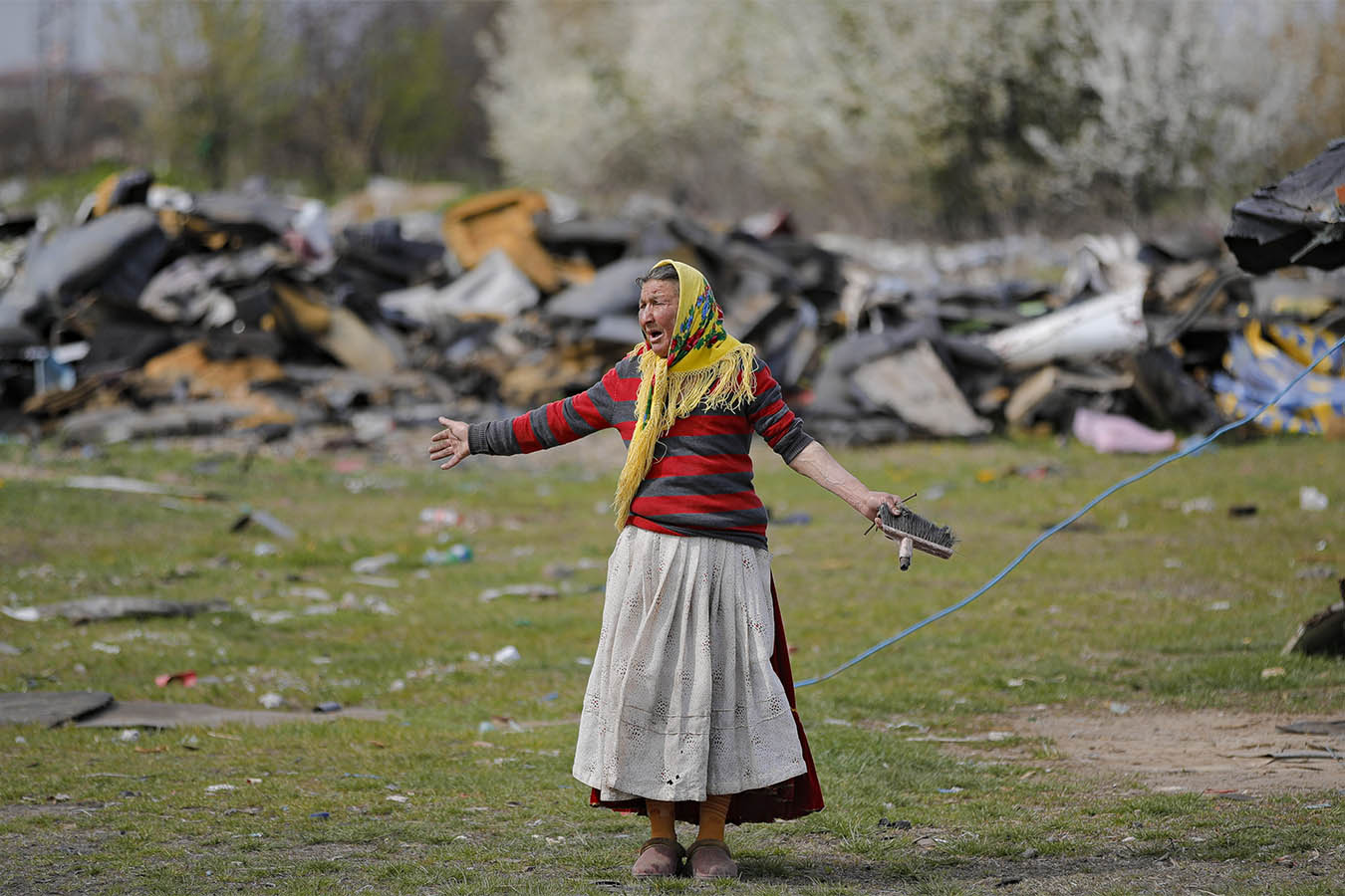 אישה במהלך פשיטה של המשמר הסביבתי בוידרה, רומניה, ה-13 באפריל 2021. אנשים רבים מתקיימים בצורה מסוכנת ובלתי חוקית על ידי הצתה של דברים המכילים מתכת כמו מחשבים, צמיגים וכבלים חשמליים (AP Photo/Vadim Ghirda)